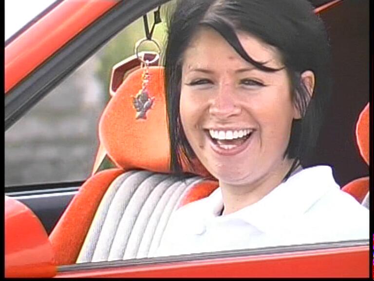 Blanka Švestáková lachend im roten Pontiac während der Dreharbeiten 2010